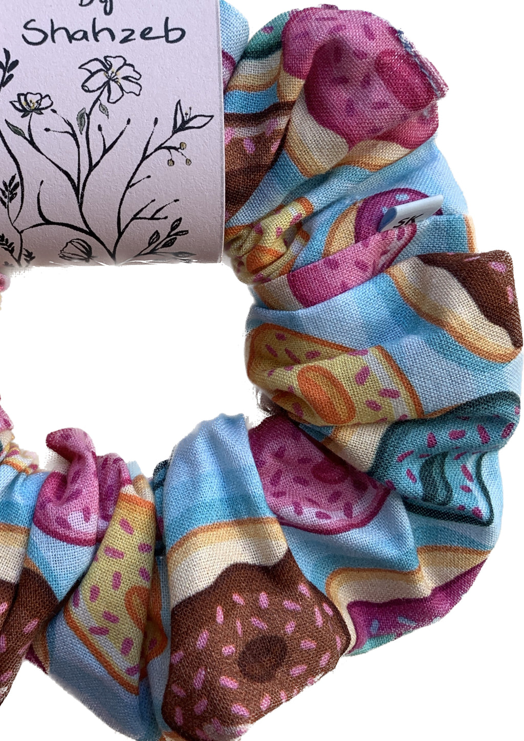 A fabric scrunchie featuring a colorful donut print.