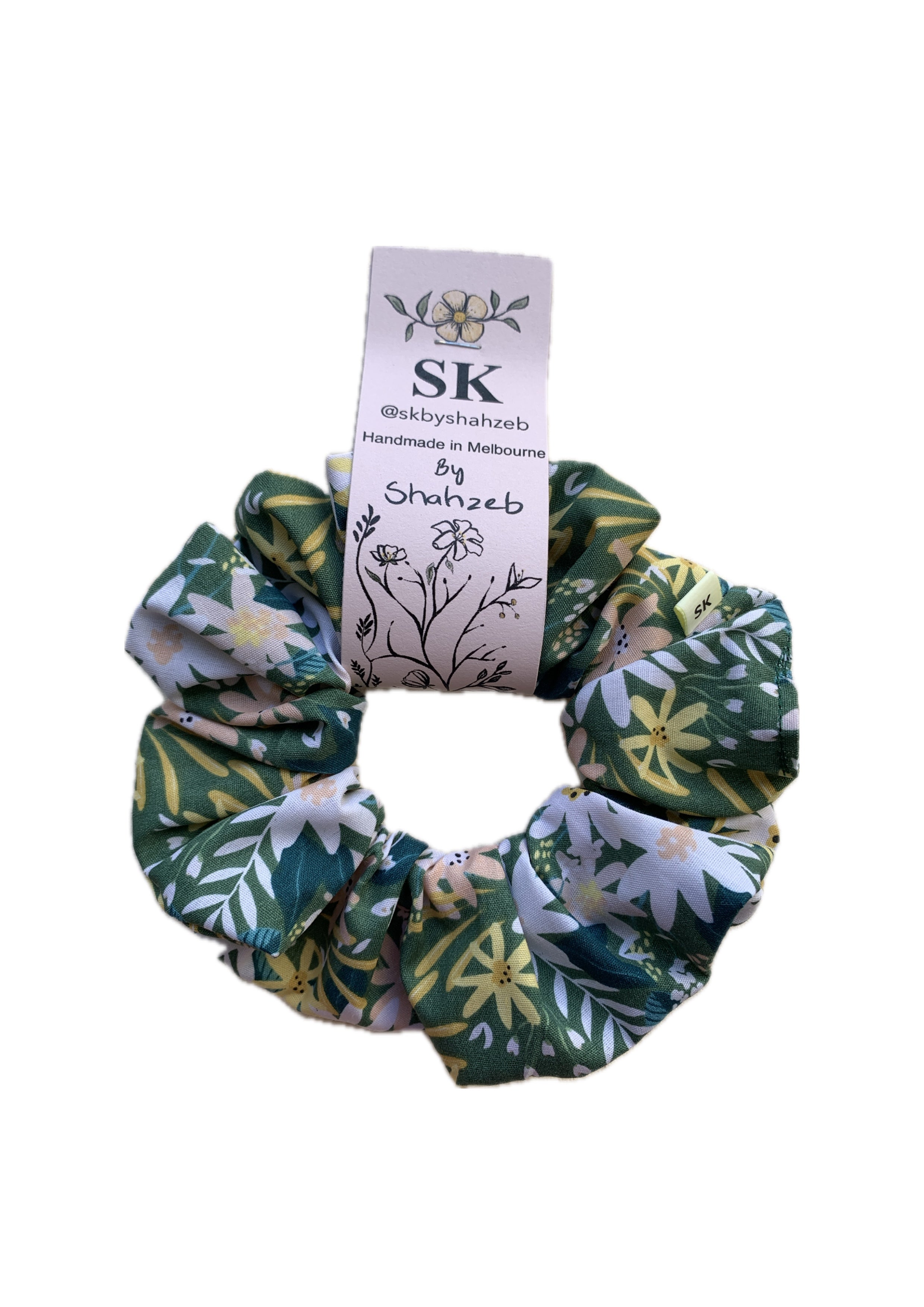 A fabric scrunchie with a green, white, and yellow floral pattern.