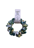 A fabric scrunchie with a green, white, and yellow floral pattern.