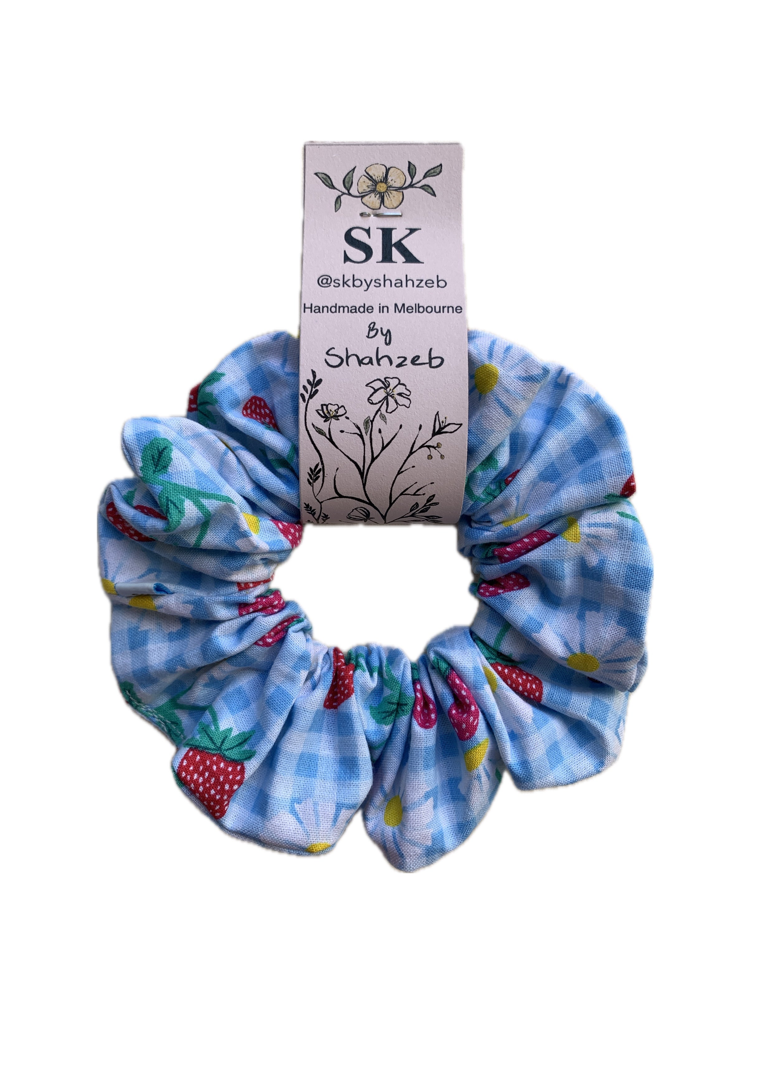 A blue and white gingham scrunchie with strawberry and yellow floral prints.