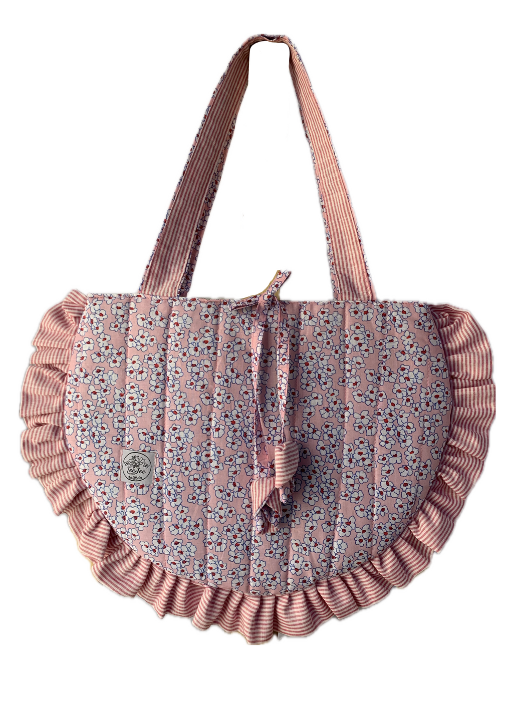 A dusty pink quilted fabric bag with a small floral print, featuring ruffled trim along the bottom edge and straps, set against a plain white background.