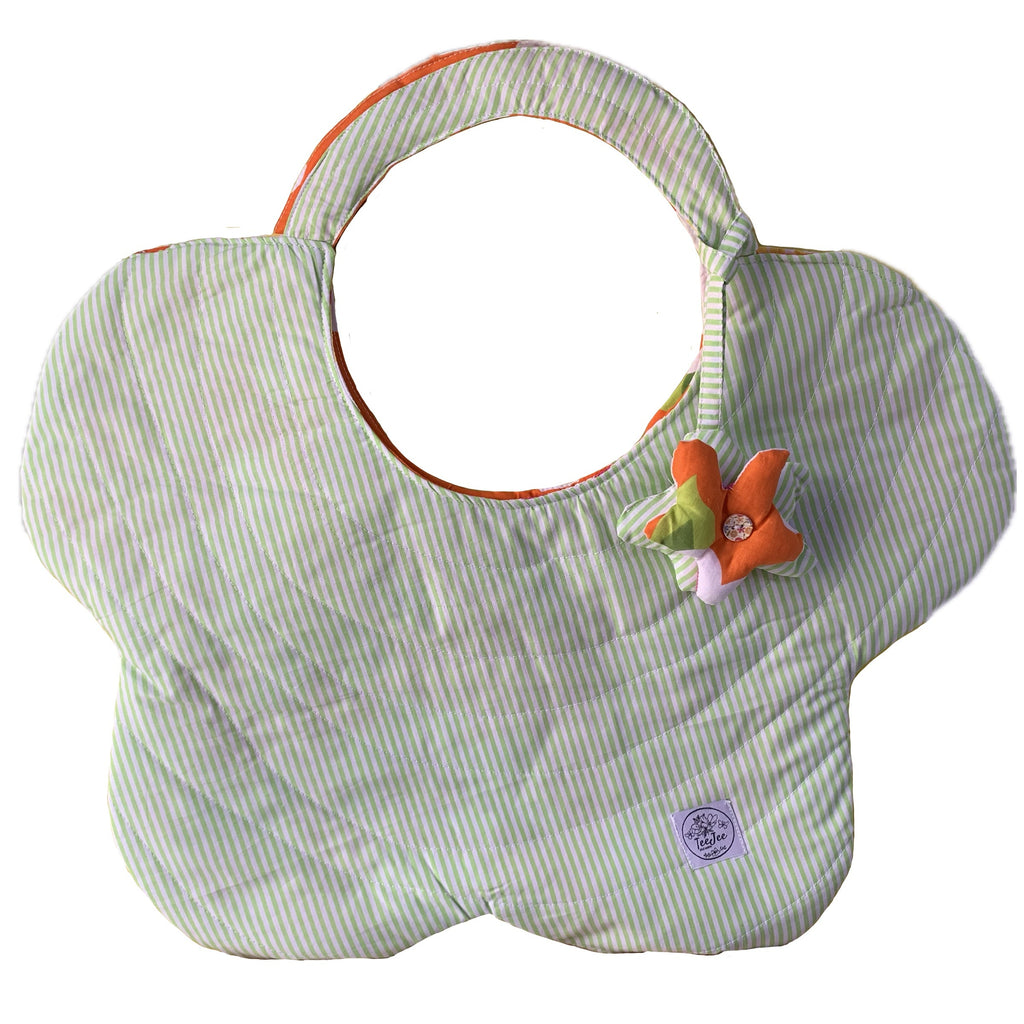 A flower-shaped quilted tote bag with pale green and white stripes, featuring an orange inner lining, a small plush flower, and a circular brand tag near the bottom.
