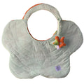 A flower-shaped quilted tote bag with pale green and white stripes, featuring an orange inner lining, a small plush flower, and a circular brand tag near the bottom.