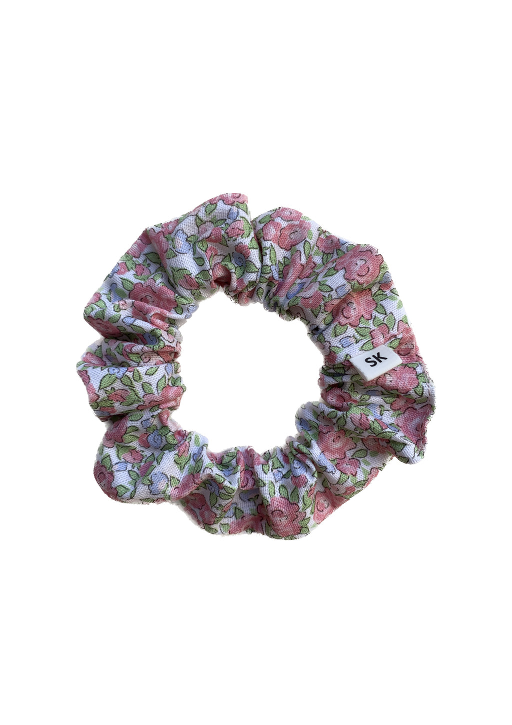A fabric hair scrunchie with a pink and green floral pattern on a white background.