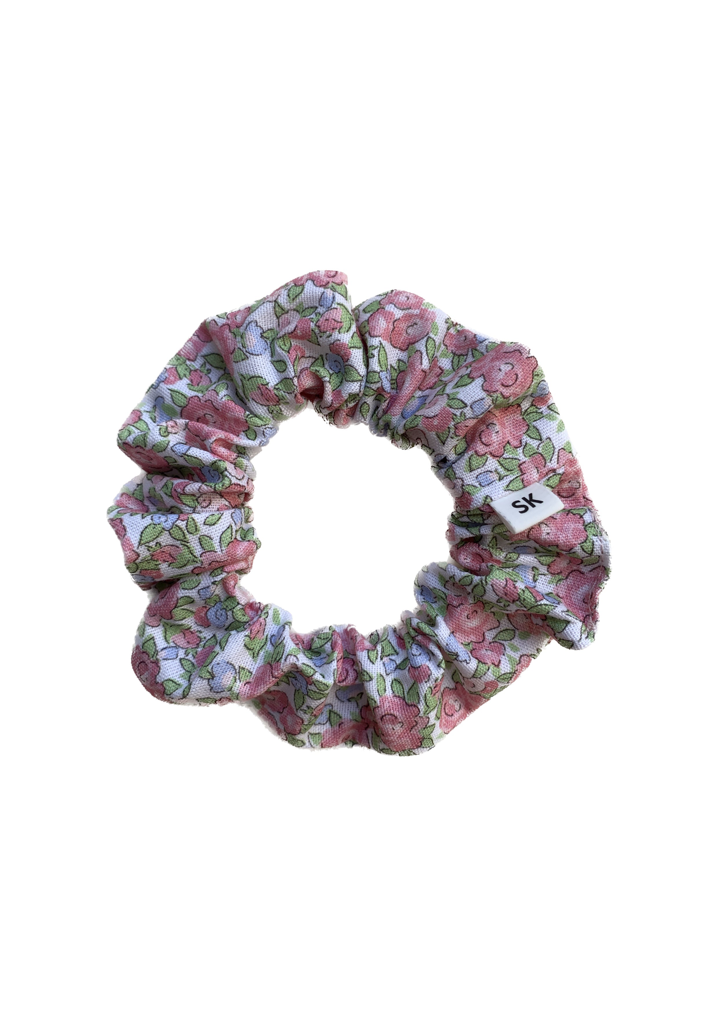 A fabric hair scrunchie with a pink and green floral pattern on a white background.