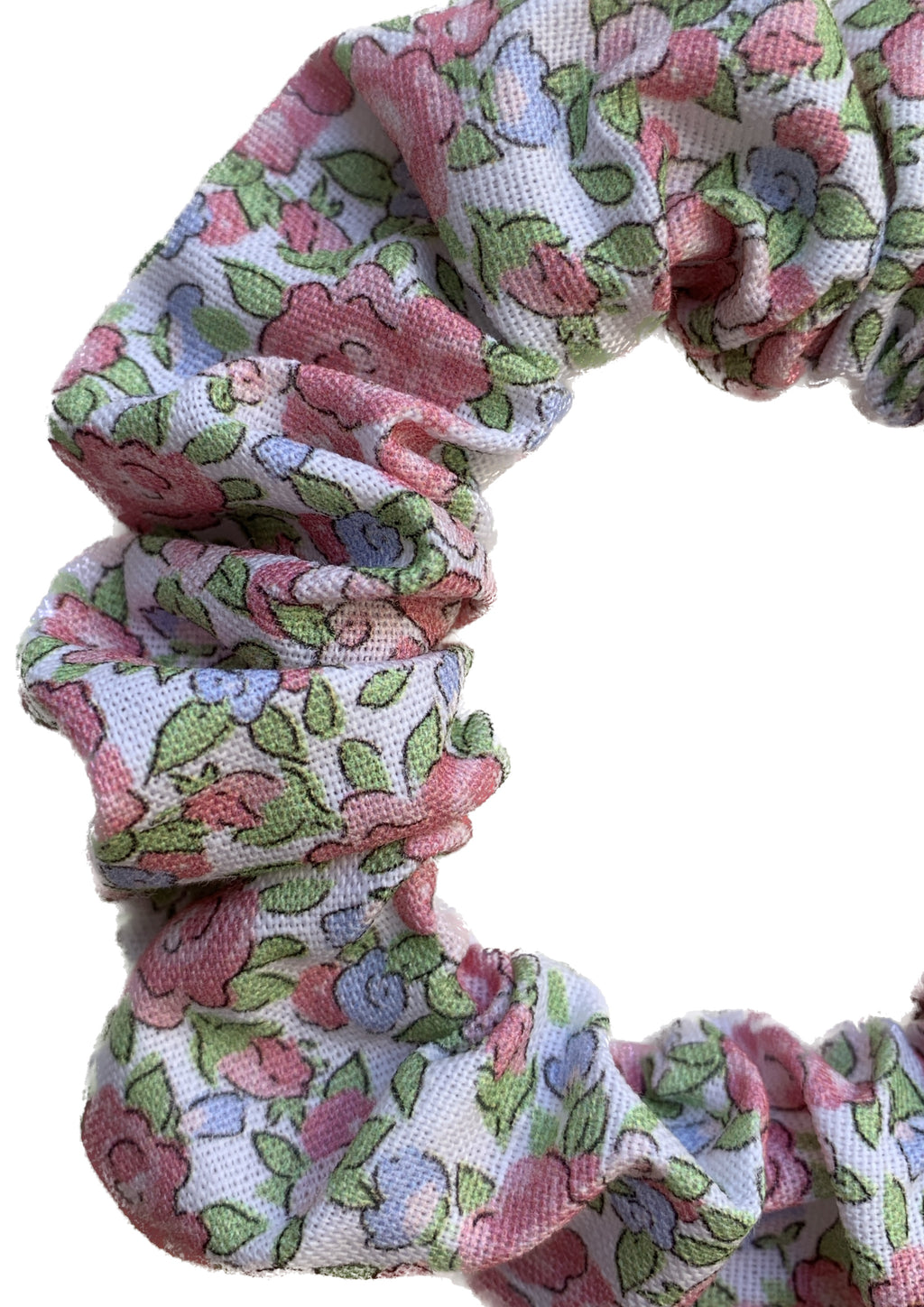 A close-up of a fabric scrunchie with a pink, green, and blue floral pattern on a white background.